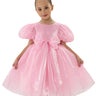 Young girl wearing a pink dress with puff sleeves on a white background