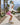 Young girl skateboarding in metallic pink skorts with palm trees and mountain views