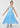 Young girl wearing a blue dress with star patterns on a white background