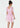 Woman wearing a pink dress with ruffled sleeves and layered skirt on a white background